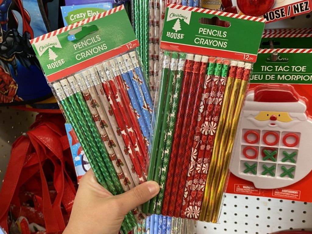 Woman holding two packs of Christmas House pencils