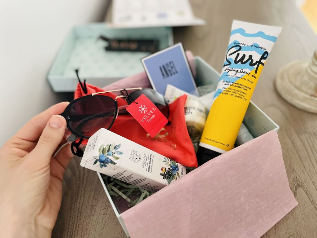 box with sunglasses, cosmetics and hair products