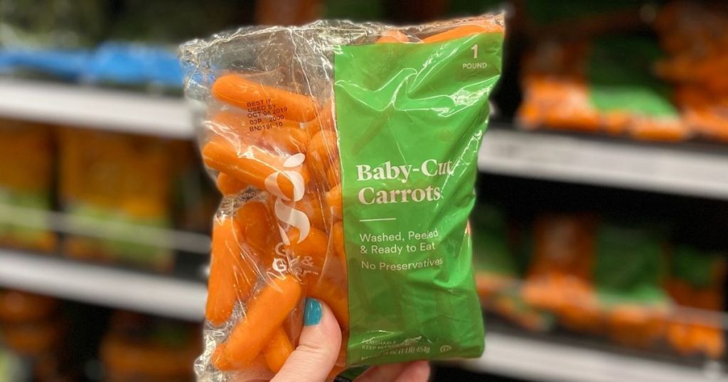 hand holding a bag of carrots