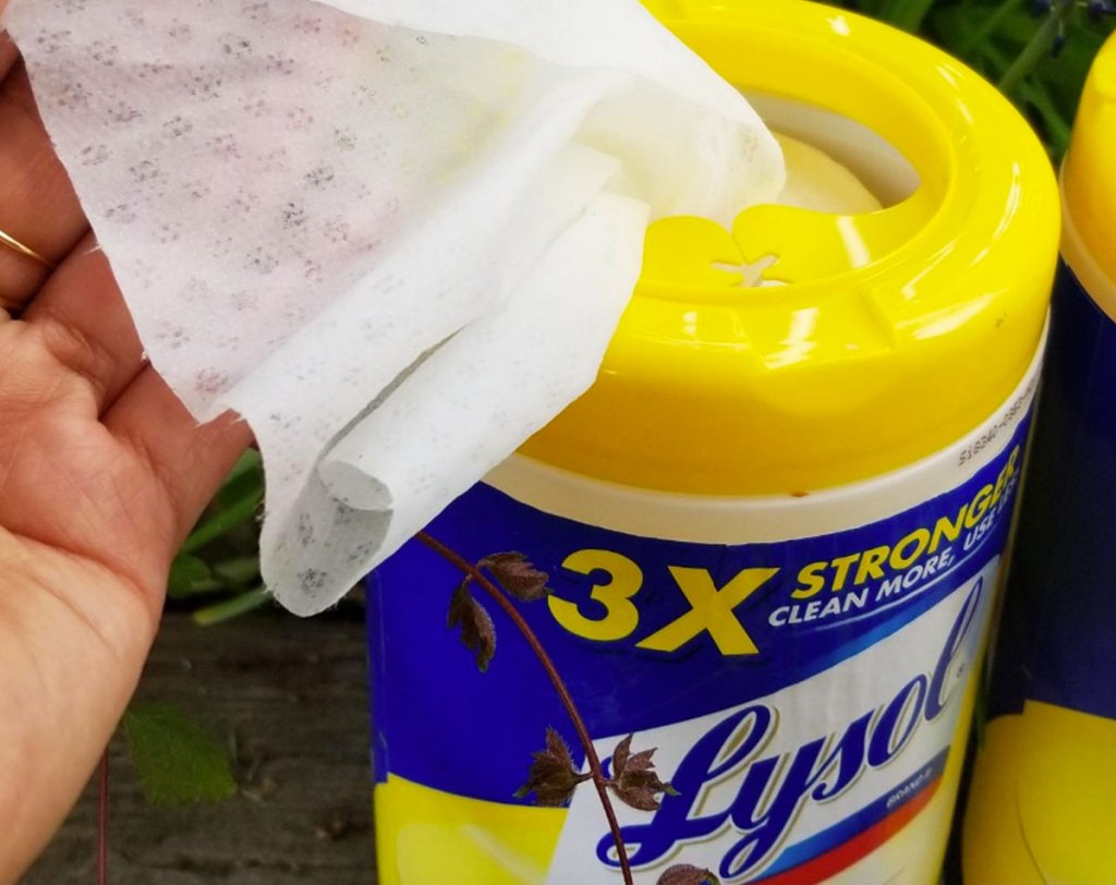 hand pulling out Lysol Wipes from yellow and blue container
