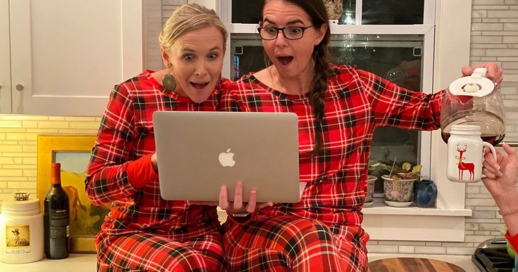 2 ladies in plaid PJs looking at MacBook Air