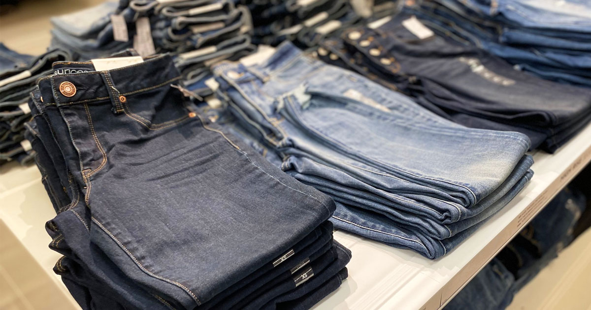 pairs of folded women's jeans on a white display table