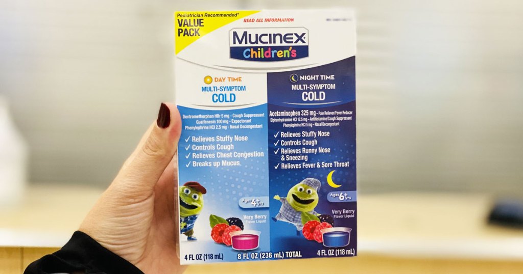 woman with dark red nails holding up a white and blue 2-pack of mucinex children's day and night time cold medicine