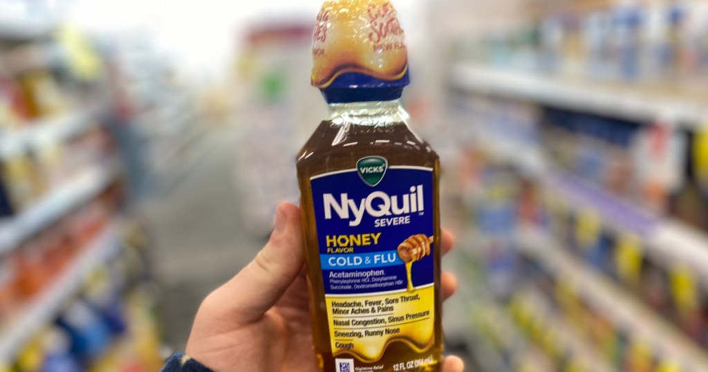 hand holding nyquil honey