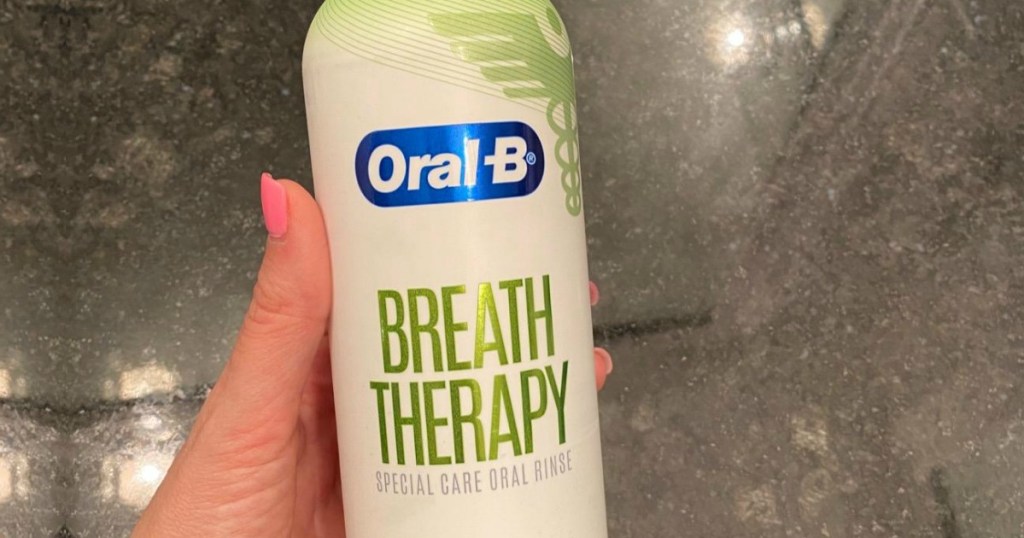 Oral B mouthwash in a bottle in-hand