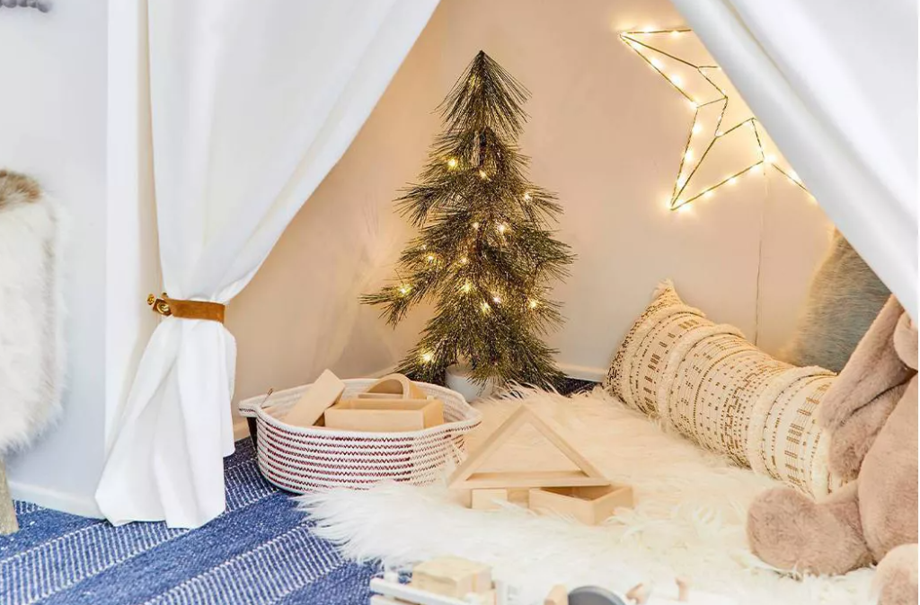 tent with a small tree, rug and toys