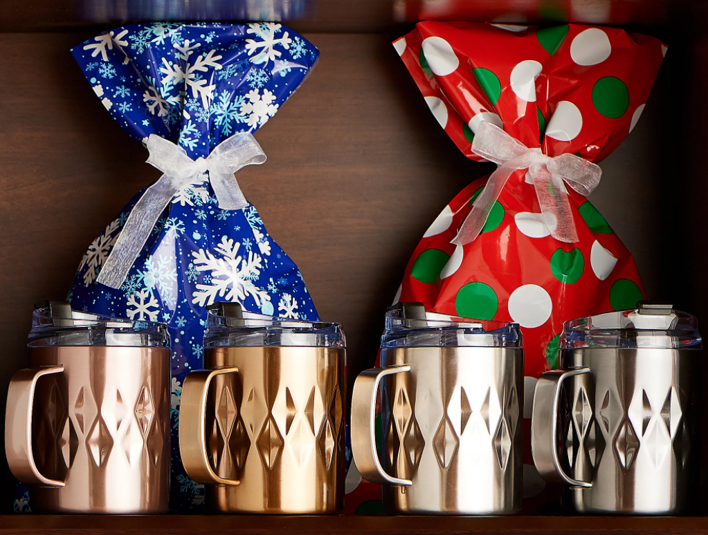 coffee mugs with gift bags behind them