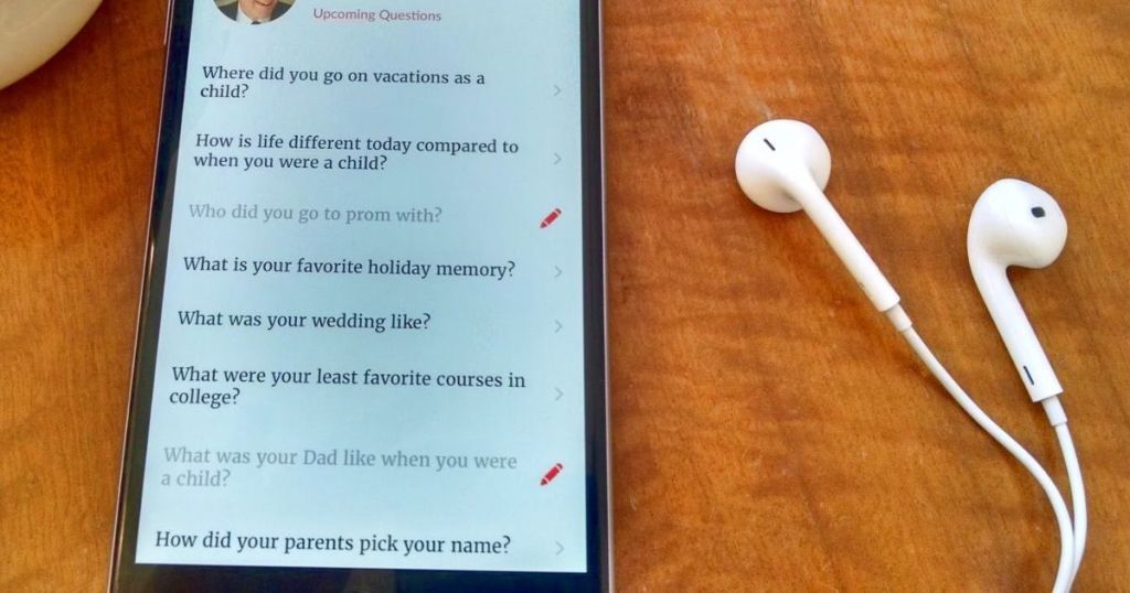 A list of questions displayed on a phone next to some headphones