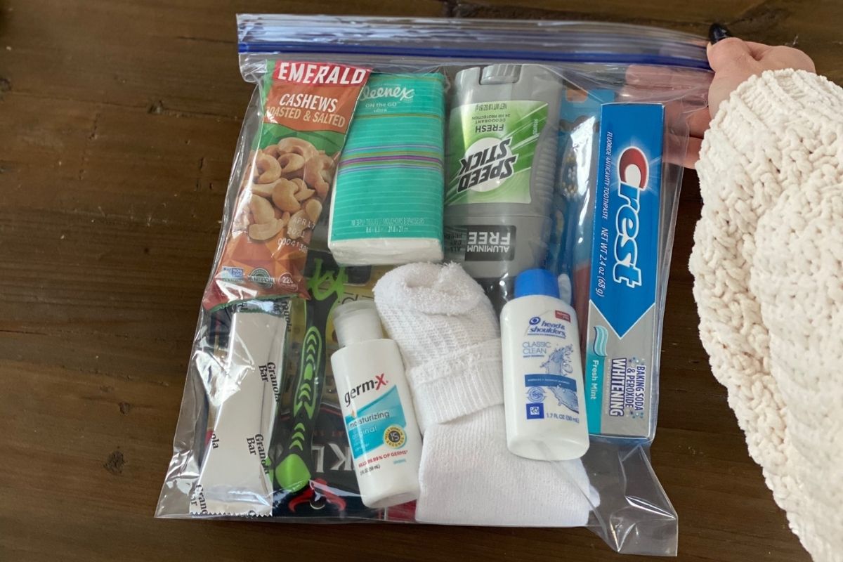 A hand holding a ziploc bag full of items