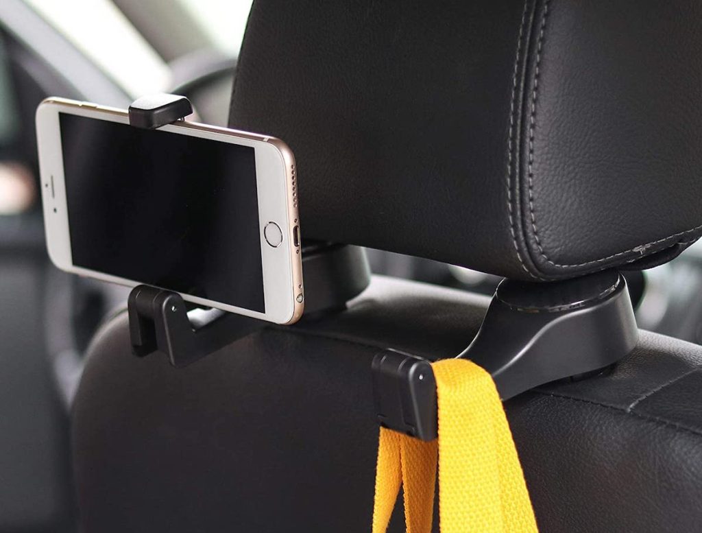 black hooks of back of car headrest holding bags and phone