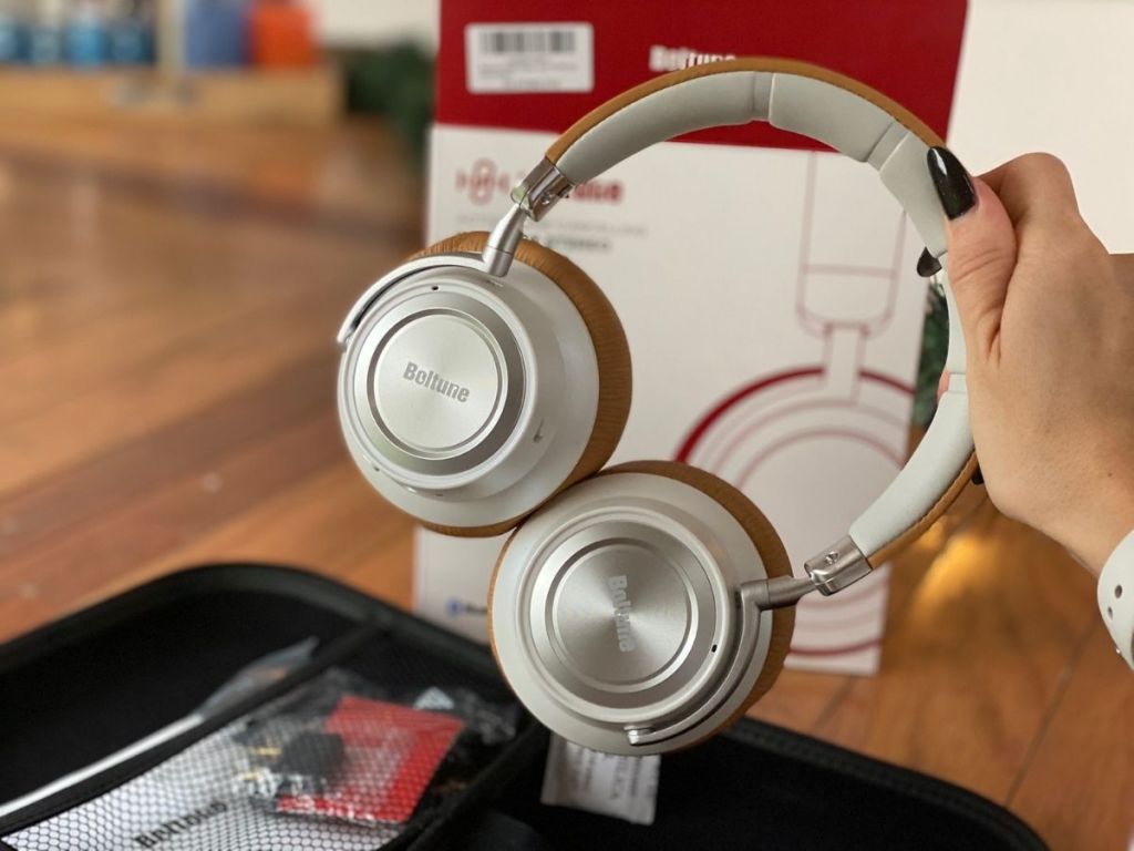 hand picking up brown Boltune headphones 