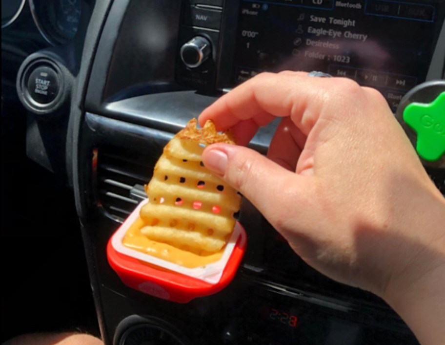 hand dipping waffle fry into dip clip