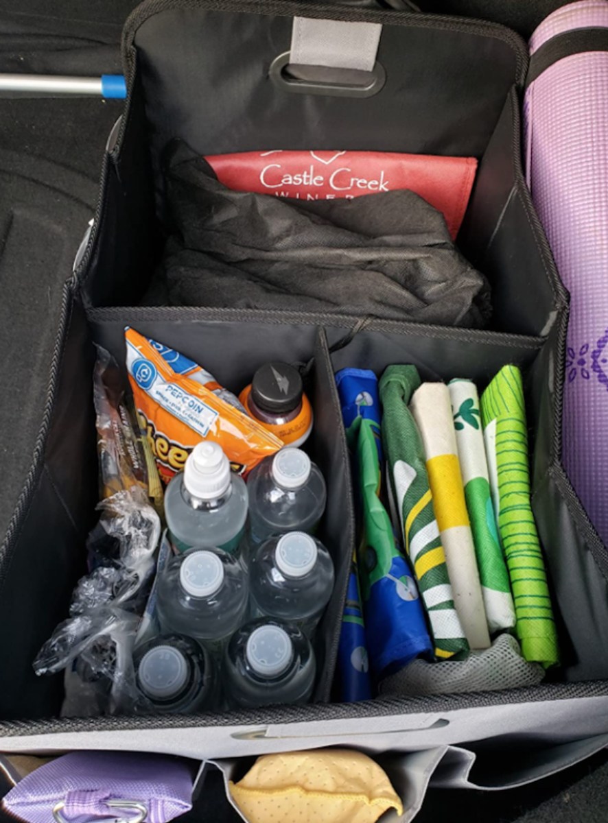 water bottles and reusable bags inside a car trunk organizer storage bin