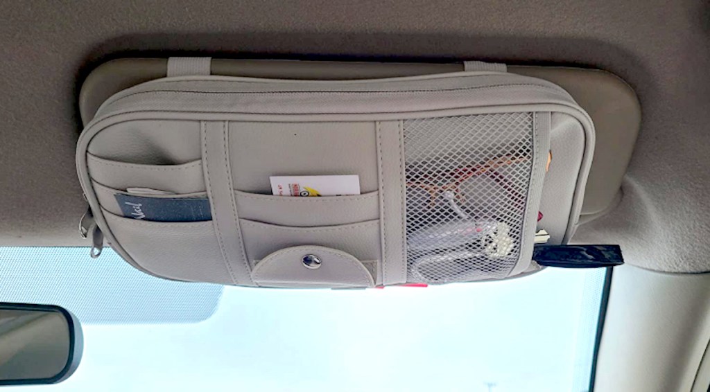 gray car visor organizer with stuff inside