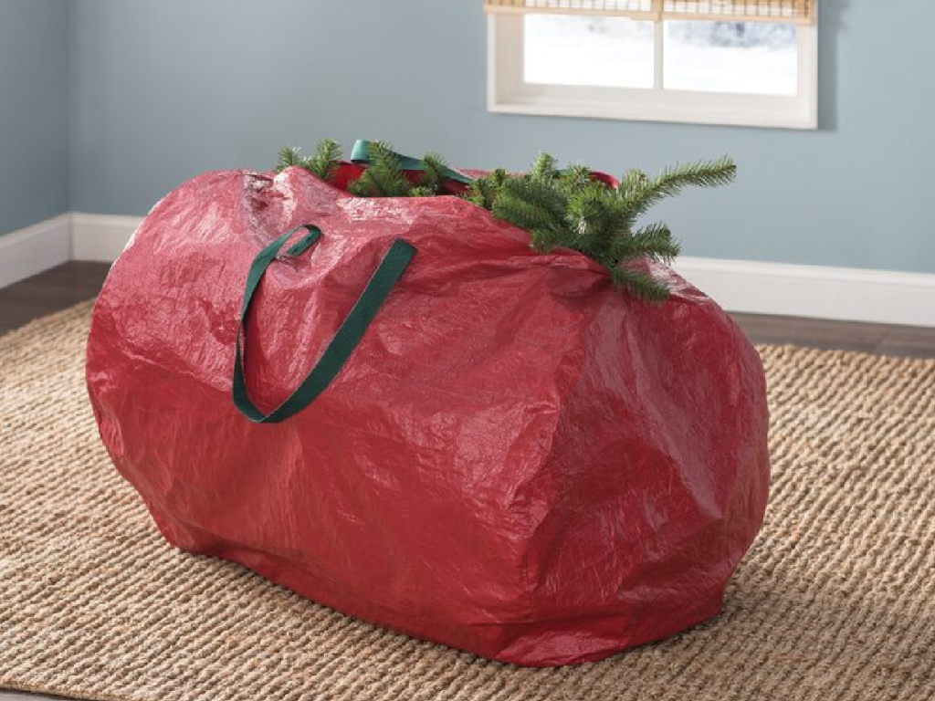 red vinyl bag holding Christmas tree in living space