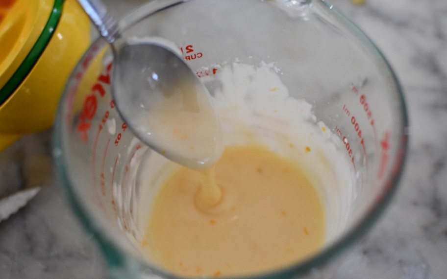 orange glaze being poured onto cake