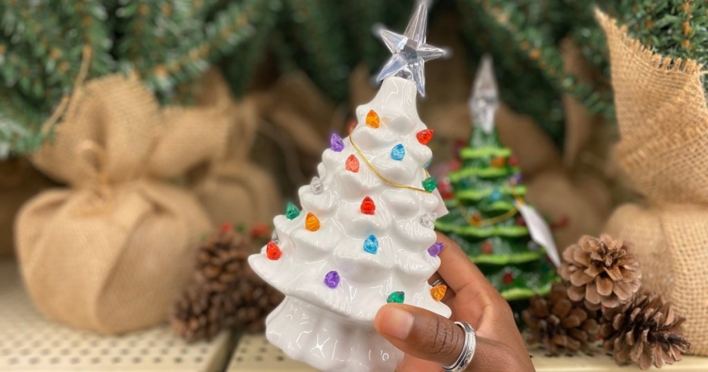 holding a white ceramic Christmas tree