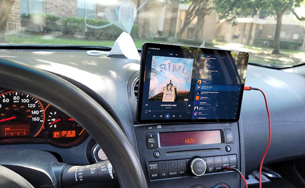 ipad hanging from car dashboard with red wire charger
