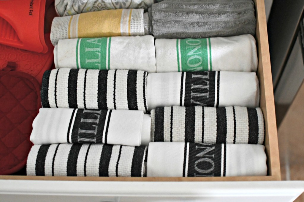 organizing kitchen towels by rolling them