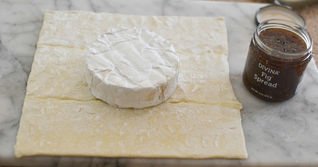 placing brie on a puff pastry sheet