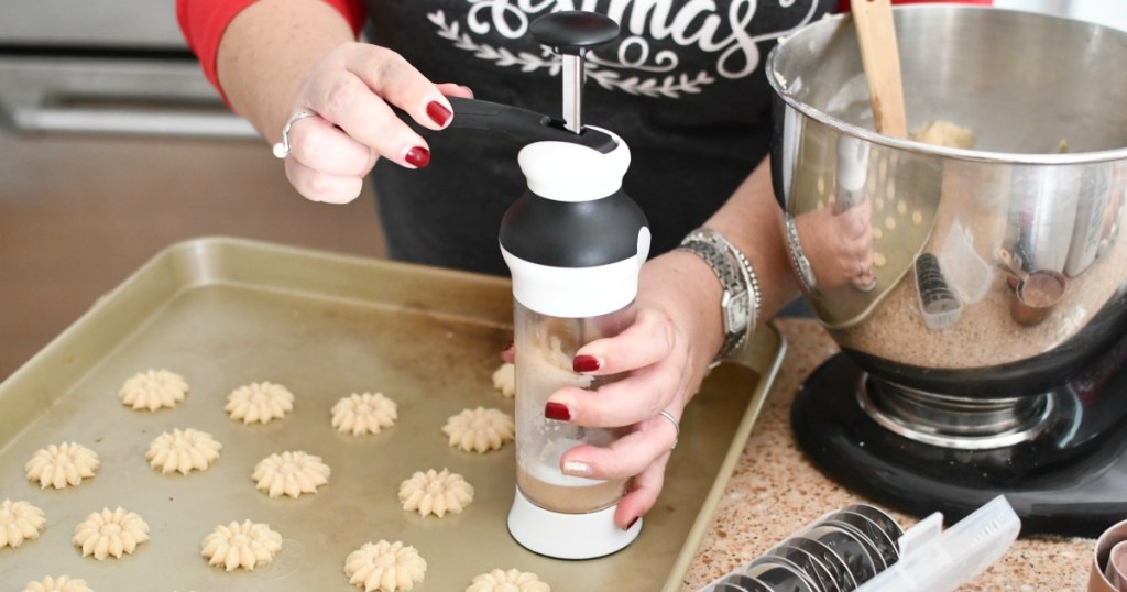 pressing cookies onto a cookie sheet using oxo cookie press