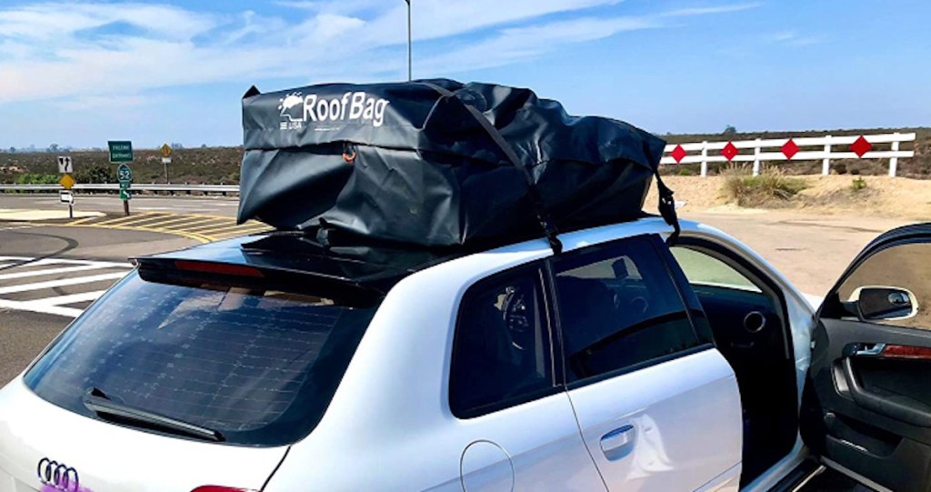 white car with black roof bag on top sitting outside