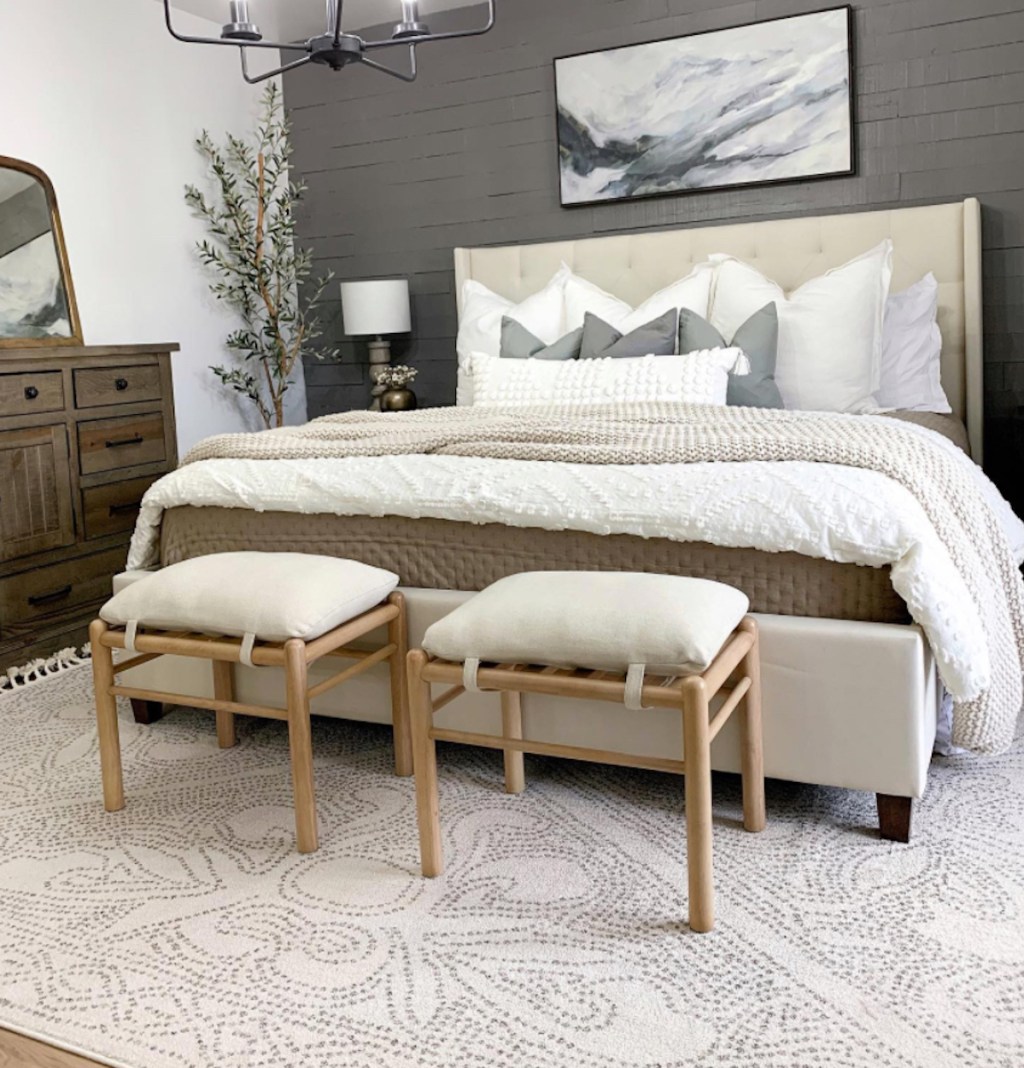 styled master bedroom with stools and neutral rug