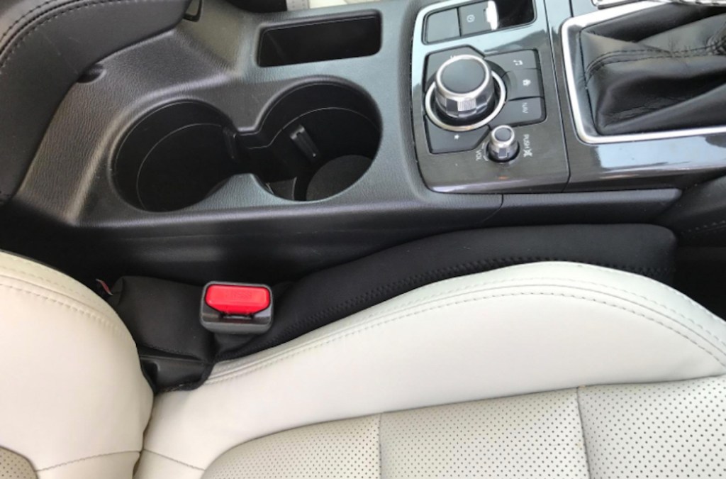 car with black gap filler in between seat and console