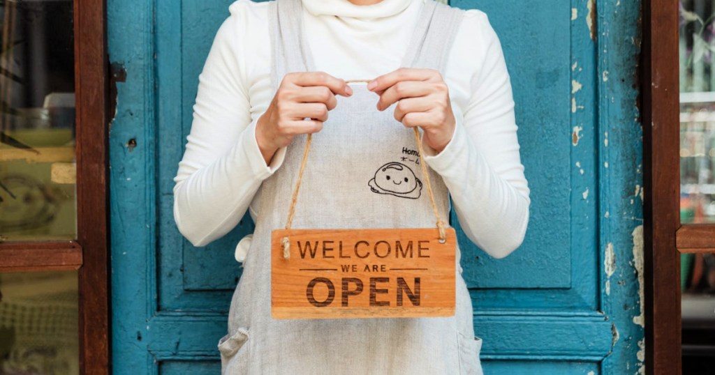 small business woman holding welcome sign