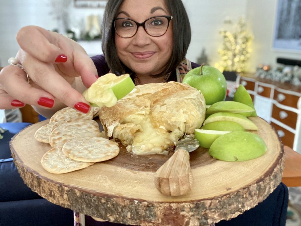 woman holding a melted brie appetizer