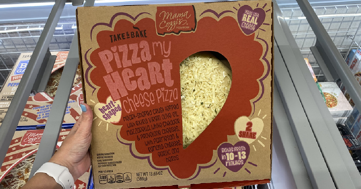 hand holding a heart shaped cheese pizza in front of an aldi refrigerated case