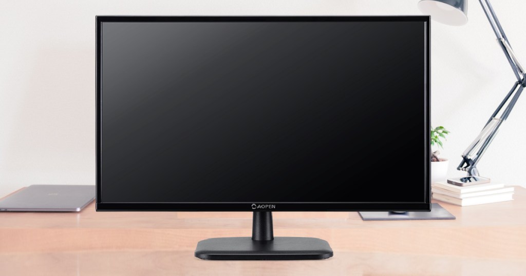 black computer monitor and lamp on desk