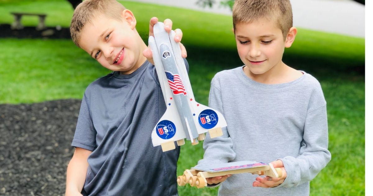 two kids holding a rocket ship