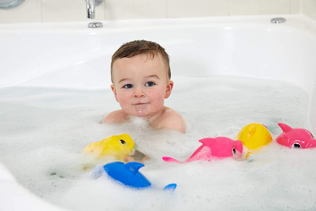boy playing in a bathtub with toys