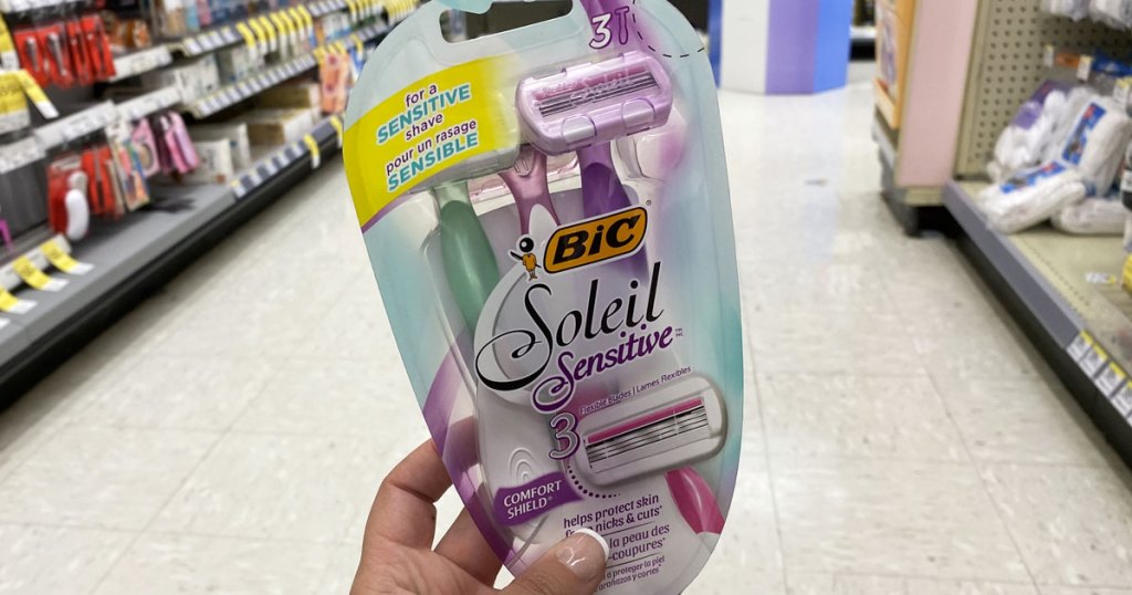 person holding up pack of bic soleil razors at walgreens