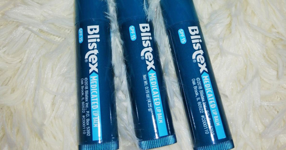three blue tubes of blistex lip balms on a fuzzy white blanket