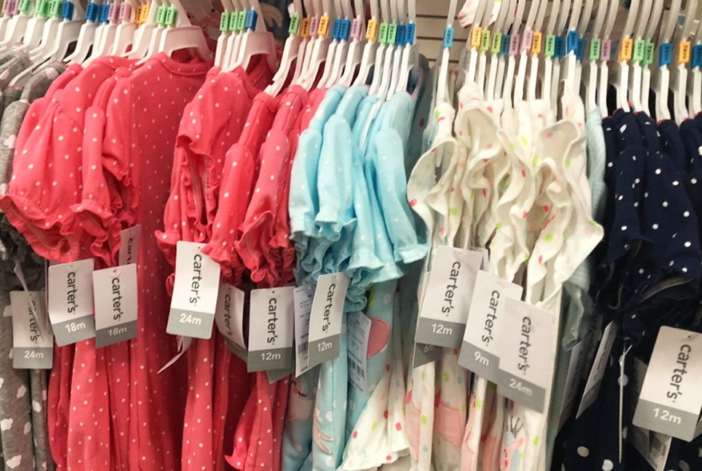 rack of carter's baby dresses hanging on hangers