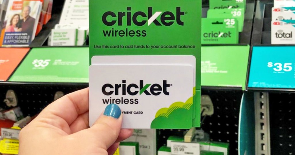 person holding up white and green cricket wireless phone card