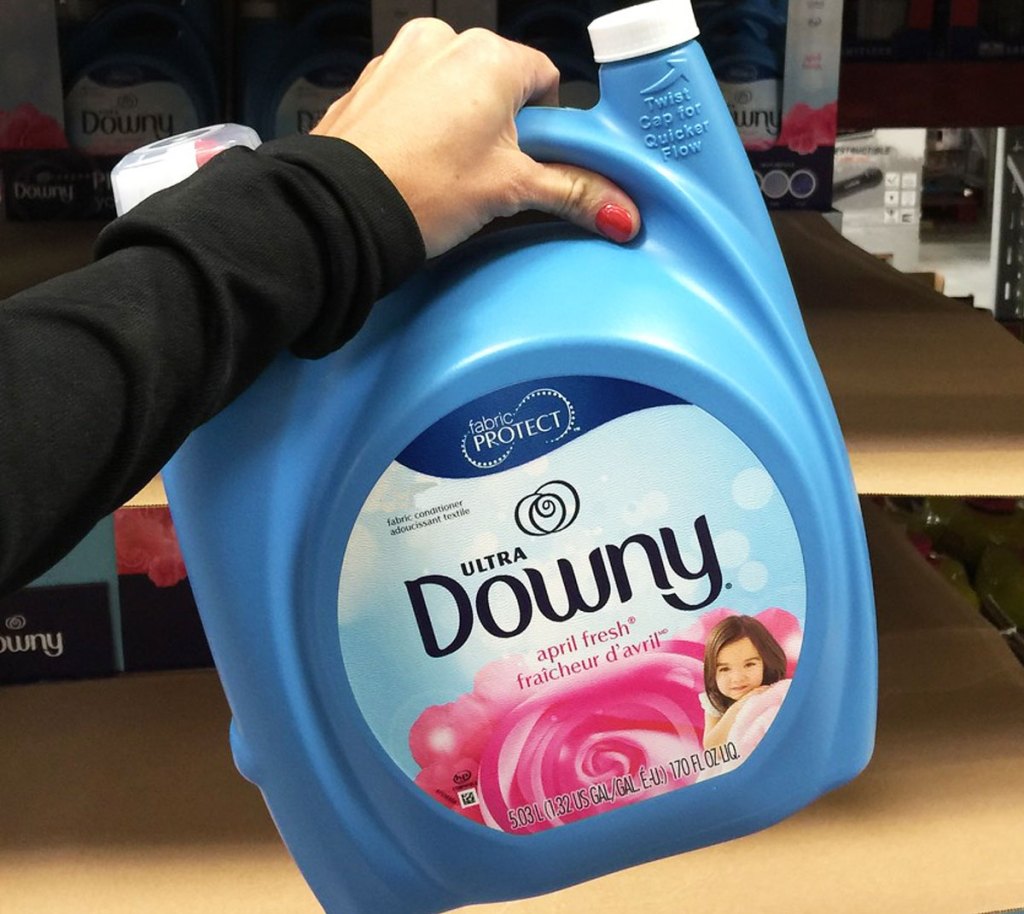 person holding up a large blue bottle of downy liquid fabric softener at sam's club