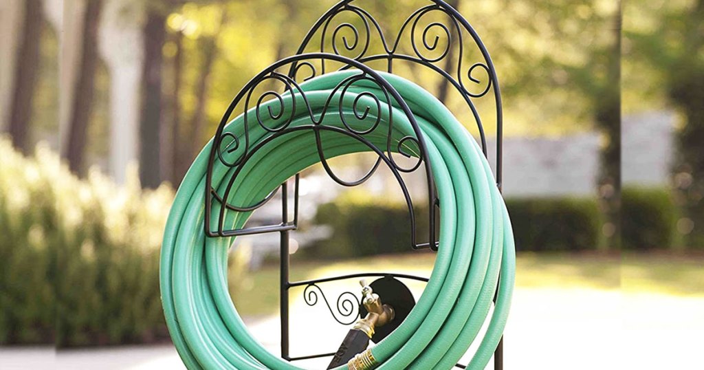 black metal garden hose stand with green hose coiled up neatly on it