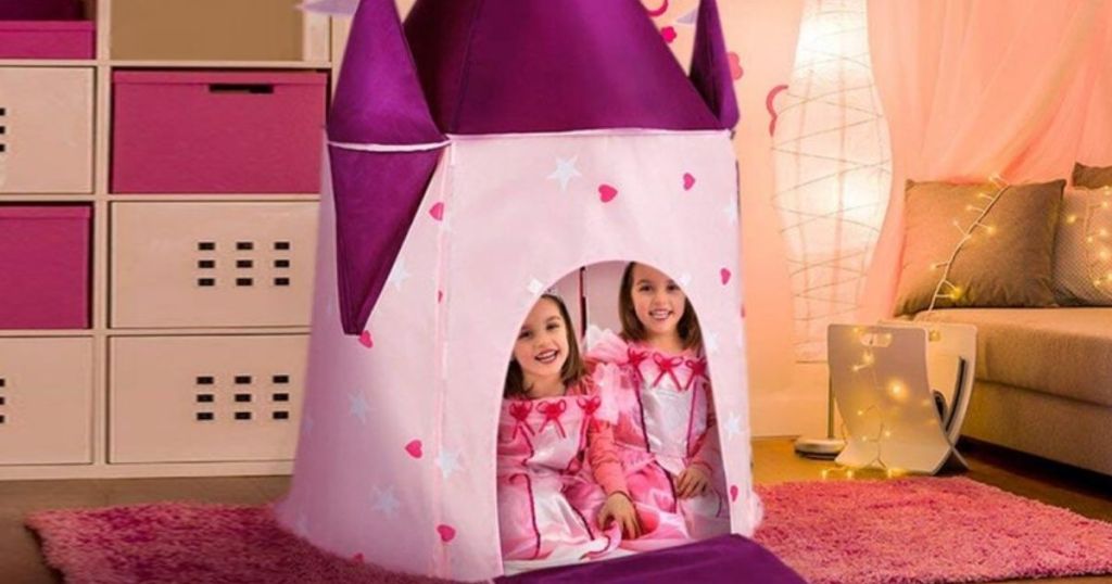 two girls dressed up like princesses in a pop-up play tent