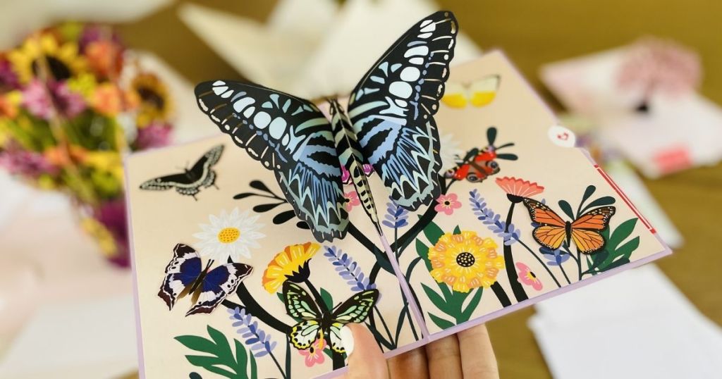 hand holding a card with a 3D butterfly