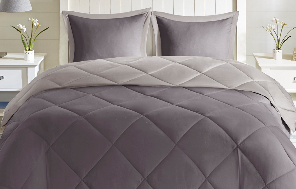 bed with grey quilt on it