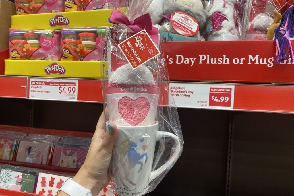hand holding Megatoys Valentine's Day Hot Cocoa and Plush Socks Mug Set