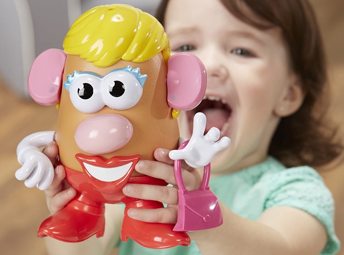 girl holding a Mrs Potato Head toy