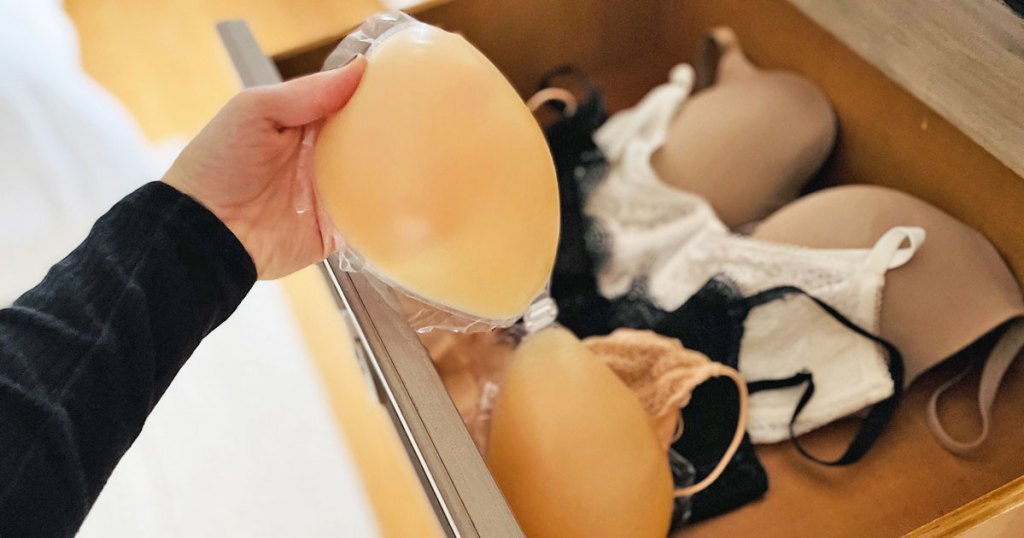 woman pulling a nude silicone adhesive bra out from bra drawer in dresser