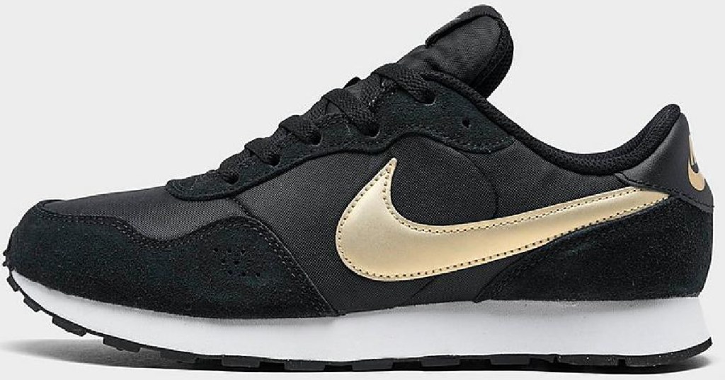 black and gold pair of nike boys sneakers