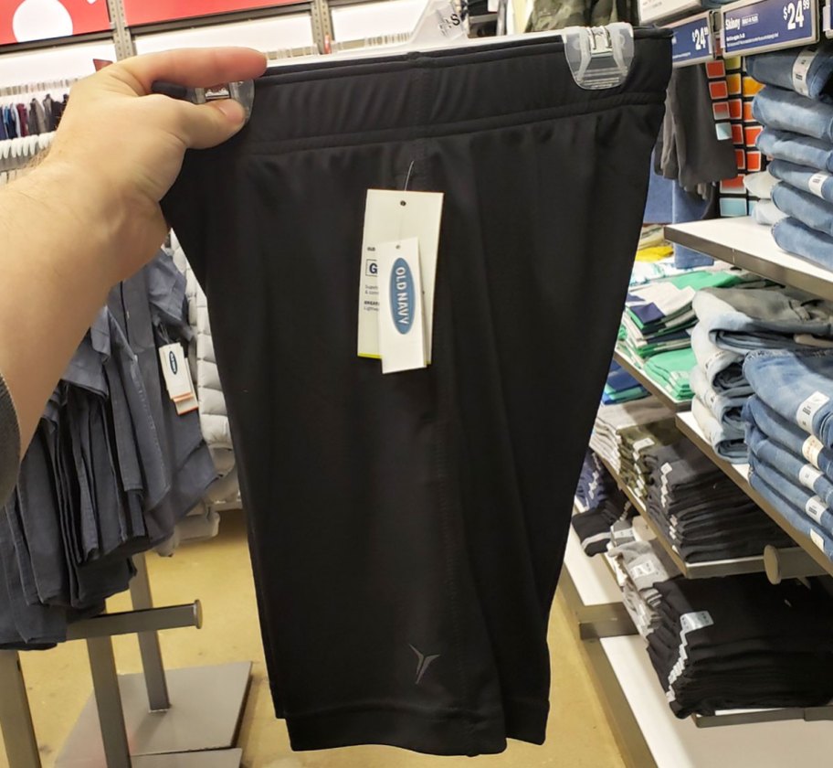 person holding up pair of men's black active shorts
