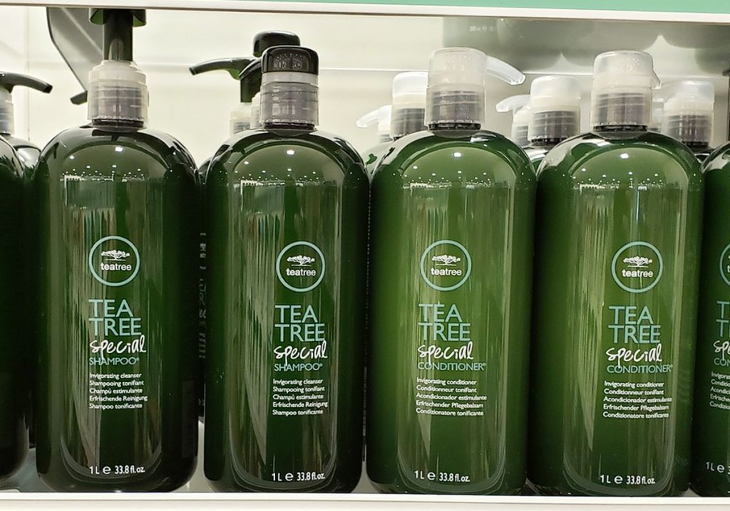 large green bottles of tea tree shampoo and conditioner on display shelf