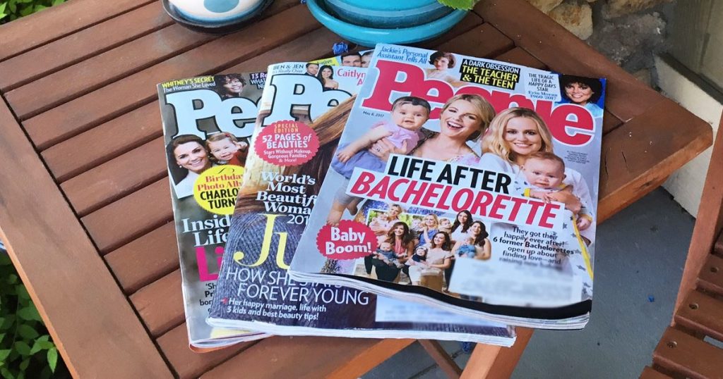 three issues of people magazine laid out on wood patio side table